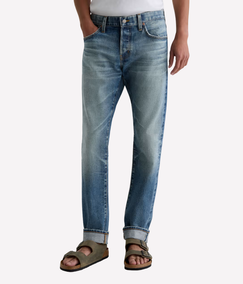 Men’s AG Tellis jeans in 14-year faded blue AG-ed™ wash, crafted from Japanese stretch selvage denim with a modern slim fit and tapered leg.
