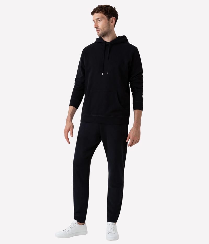 Men’s slim fit track pants in black, crafted from loopback cotton with ribbed waistband and tapered leg—part of a matching track set.