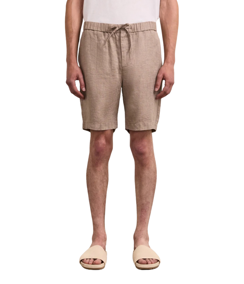 Person wearing beige shorts on a white background