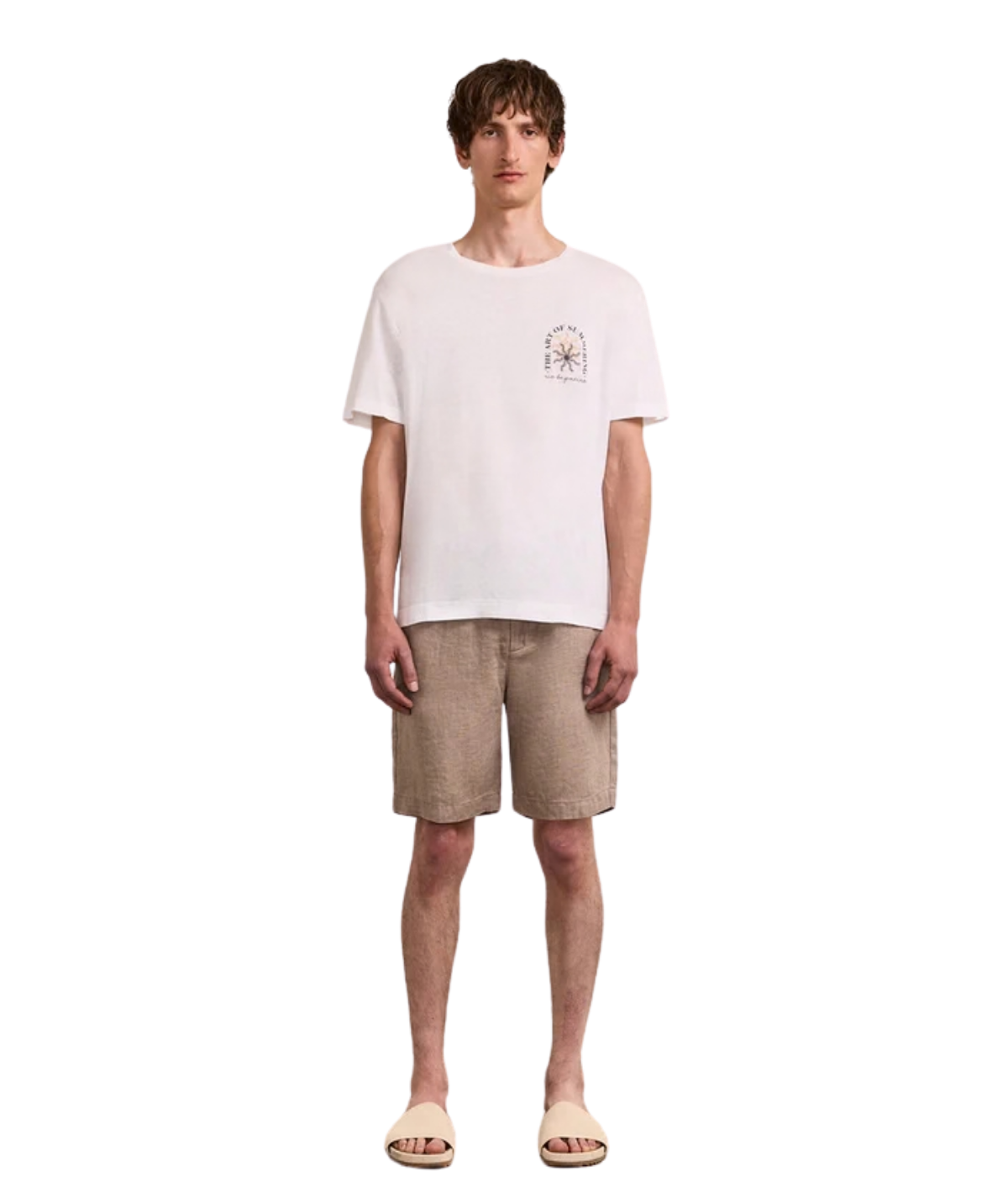 Man wearing a white t-shirt with a small graphic and beige shorts on a white background
