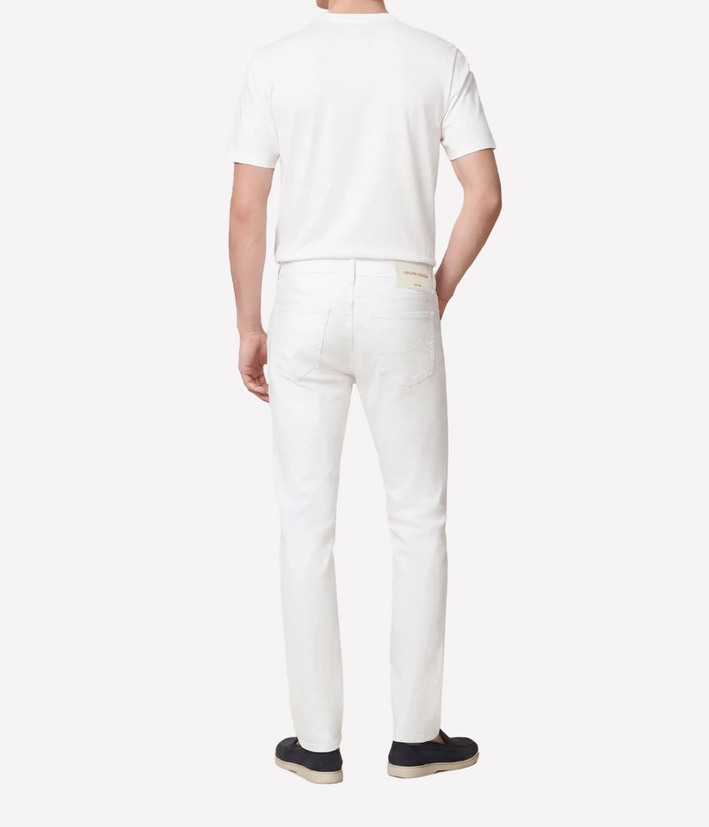 Man wearing Jacob Cohën Bard Slim Fit Pant in White with a white T-shirt and dark shoes, back view