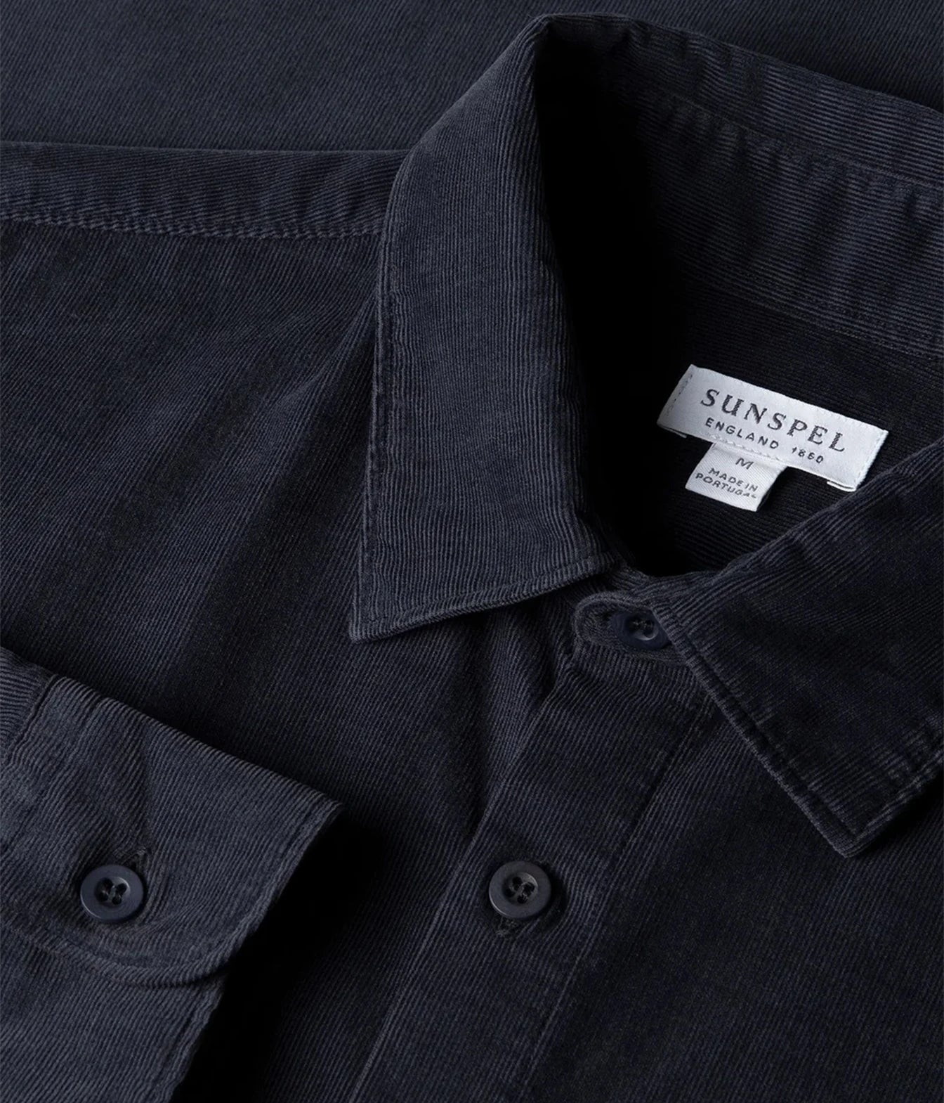 Close-up of a dark navy corduroy button-down shirt collar with a visible SUNSPPL brand label.