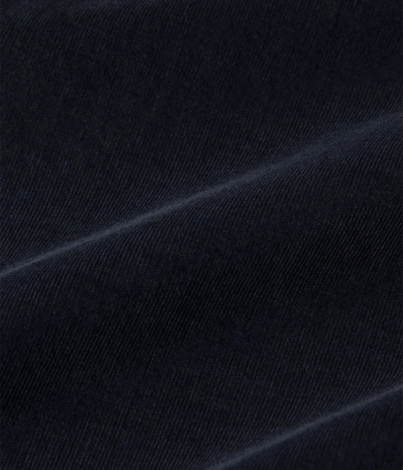 A close-up of dark navy blue fabric with a fine diagonal twill texture and soft folds.