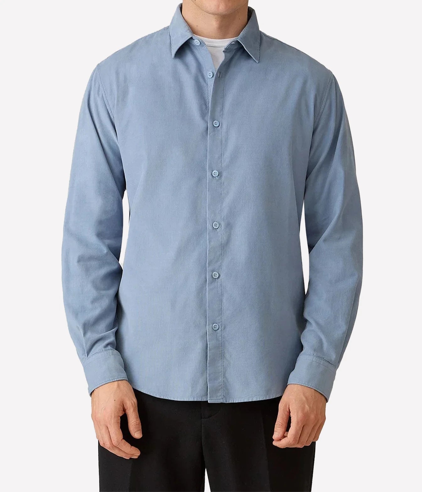 A man wearing a light blue long-sleeve button-down shirt with black pants, shown from the neck down against a plain light gray background.