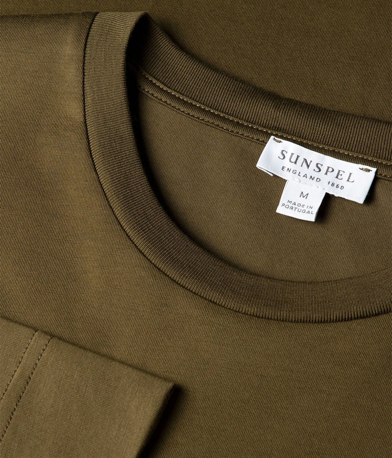 Close-up of a crewneck sweatshirt in olive green, showing the ribbed collar and a white brand label for SUNSPEL.