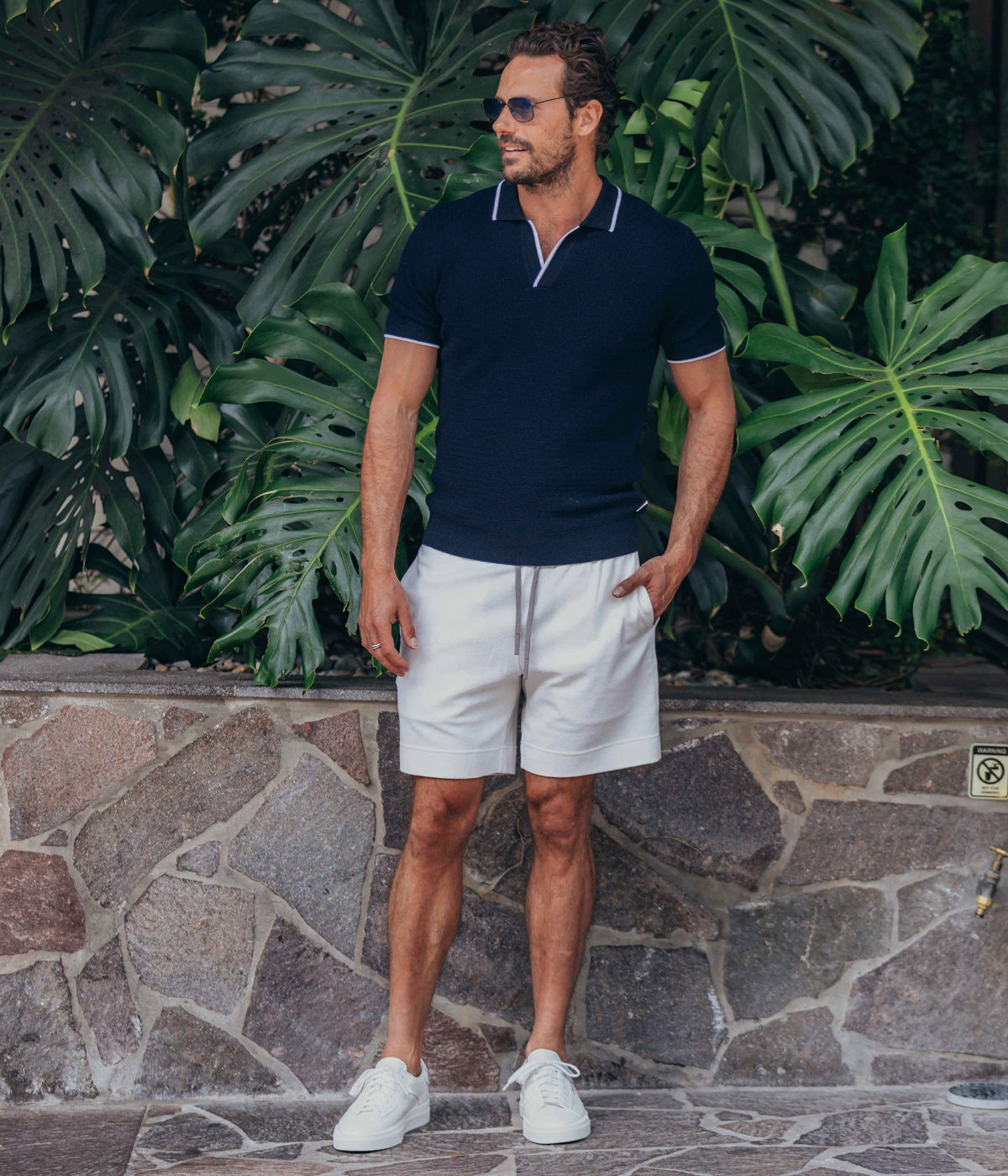 Navy Horton polo shirt featuring a tailored fit and fine stripe detail on the collar, cuffs, and hem. Made from 100% Merino wool with a waffled knit for comfort and durability. Dry clean only