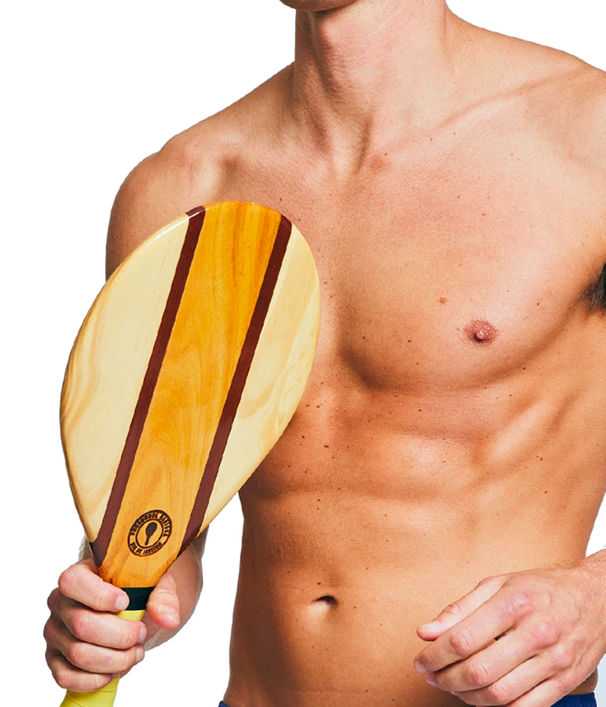 A person holding the Frescobol Carioca Beach Bats with the hand-wrapped neoprene grip, ready for a game by the sea. The sleek wooden design is inspired by Brazil’s beach culture.
