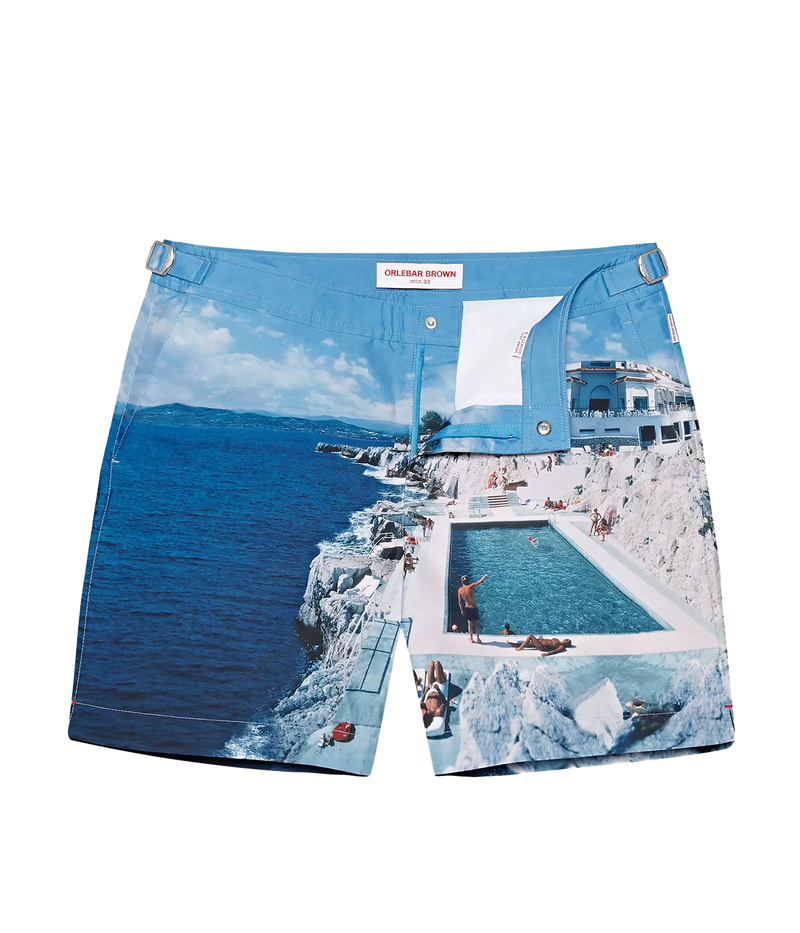 Orlebar Brown Bulldog Swim Shorts featuring a Slim Aarons medley of inviting blues from the iconic Roc Pool shot, offering effortless style and quick-dry fabric for ultimate summer versatility.