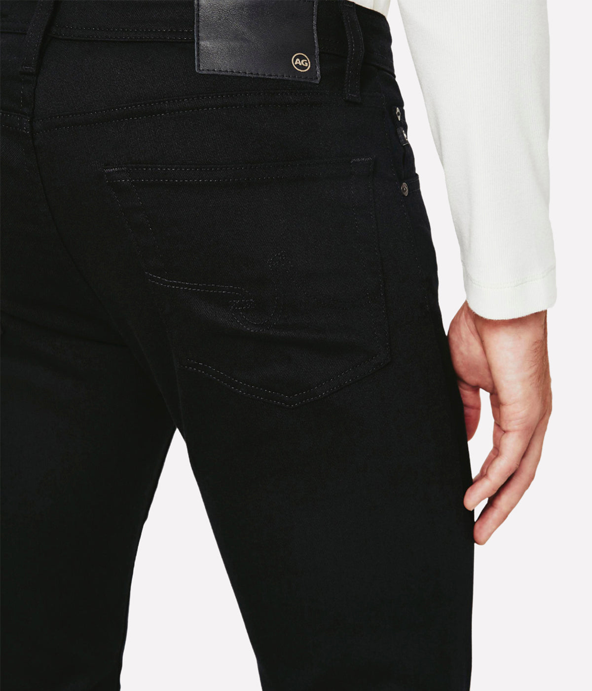 Back view of the Dylan jeans in deep black, highlighting the slim fit through the thighs and the tapered leg opening, offering a sharp, contemporary look. The fade-proof fabric ensures a long-lasting, saturated black colour.