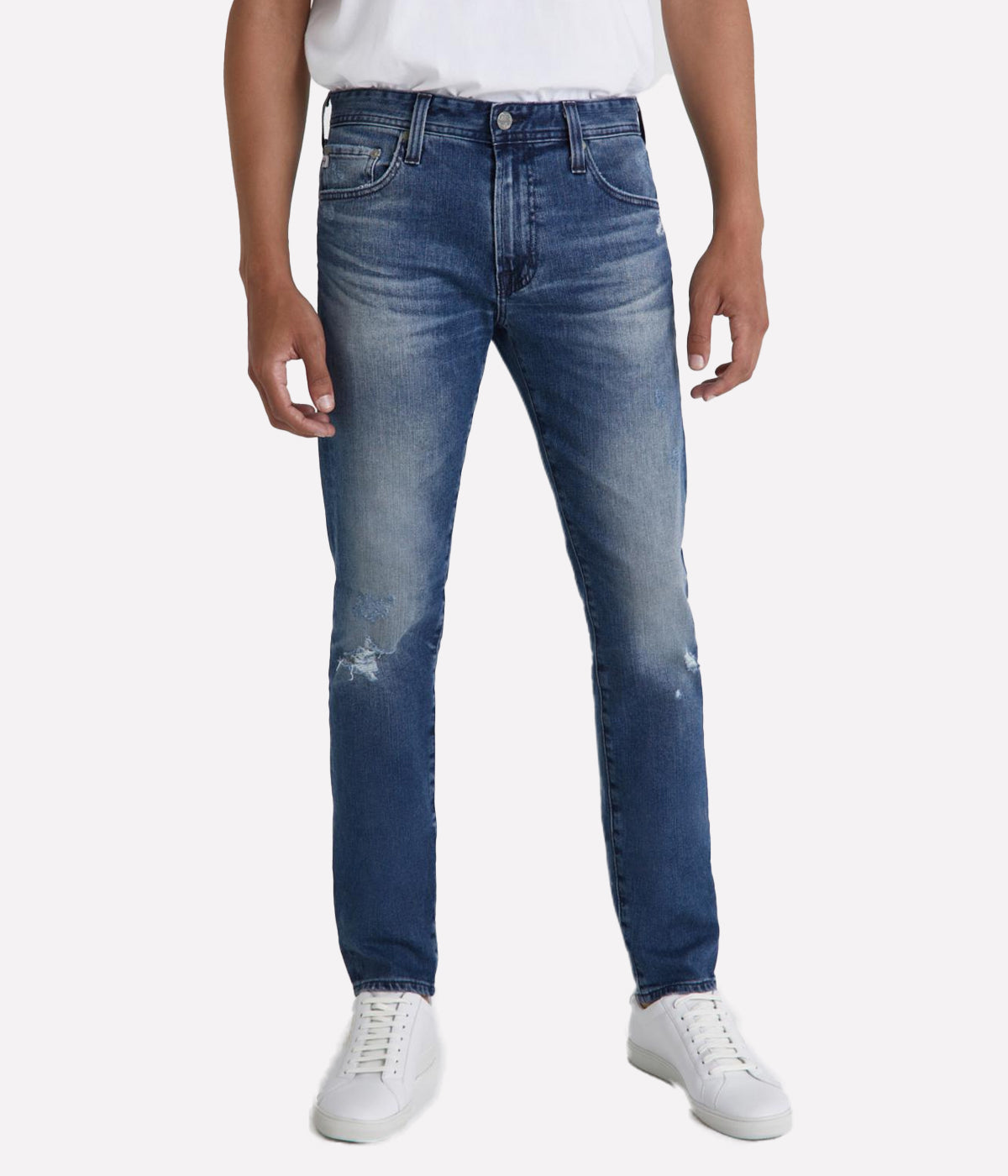 The Dylan Slim Skinny Jeans by AG Jeans in a medium wash with distressed details and knee destruction, featuring a slim fit through the thighs and tapered leg openings.