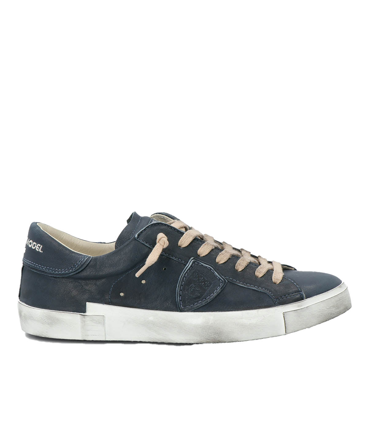 Side view of Philippe Model PRSX Low Man sneakers showcasing the unique vintage-effect design, with a patented foxing tape creating an imperfect sole. The shield on the side features the City of Paris coat of arms. The upper is crafted from high-quality Italian calfskin and suede, with laminated suede inserts.